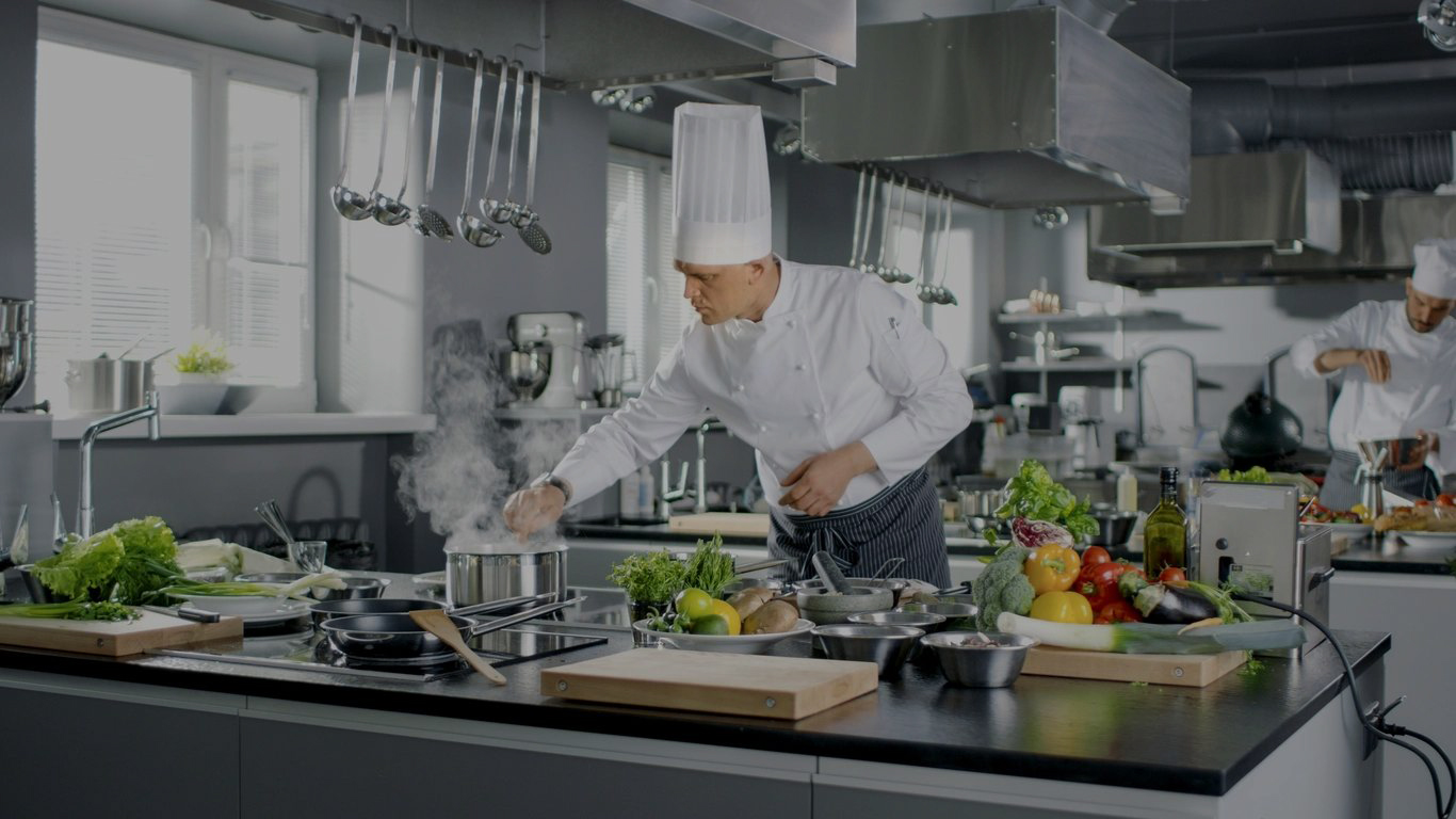 A chef is cooking in the kitchen preparing food.